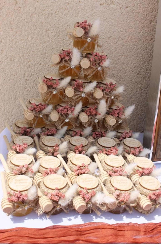 Pots de Miel Framboise personnalisés pour le baptême d’Emma, présentation en pyramide avec fleurs roses