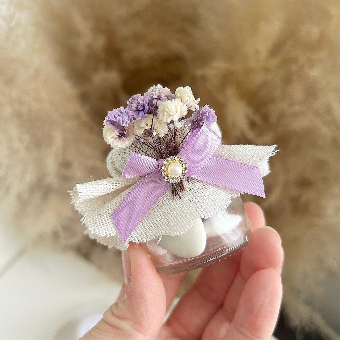 Petites bougies cadeaux invités décorées de rubans violines et fleurs séchées