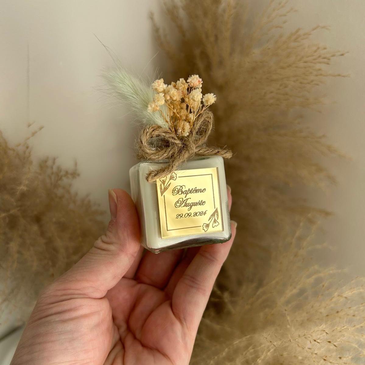 Cadeau invité baptême : bougie blanche style bohème avec jute et fleurs séchées, personnalisée avec prénom et date.