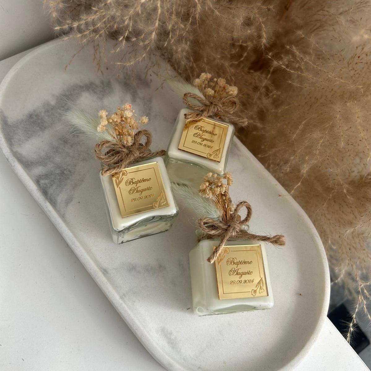 Cadeau invité baptême : bougie blanche style bohème avec jute et fleurs séchées, personnalisée avec prénom et date.