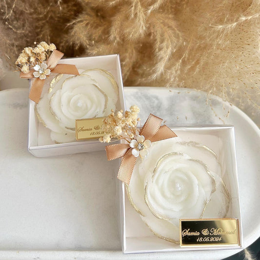 Cadeau invité mariage : bougie en forme de rose avec finitions dorées, fleurs séchées et étiquette personnalisée.