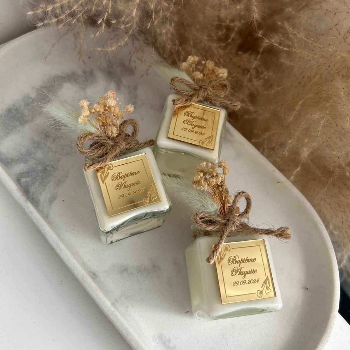 Cadeau invité baptême : bougie blanche style bohème avec jute et fleurs séchées, personnalisée avec prénom et date.