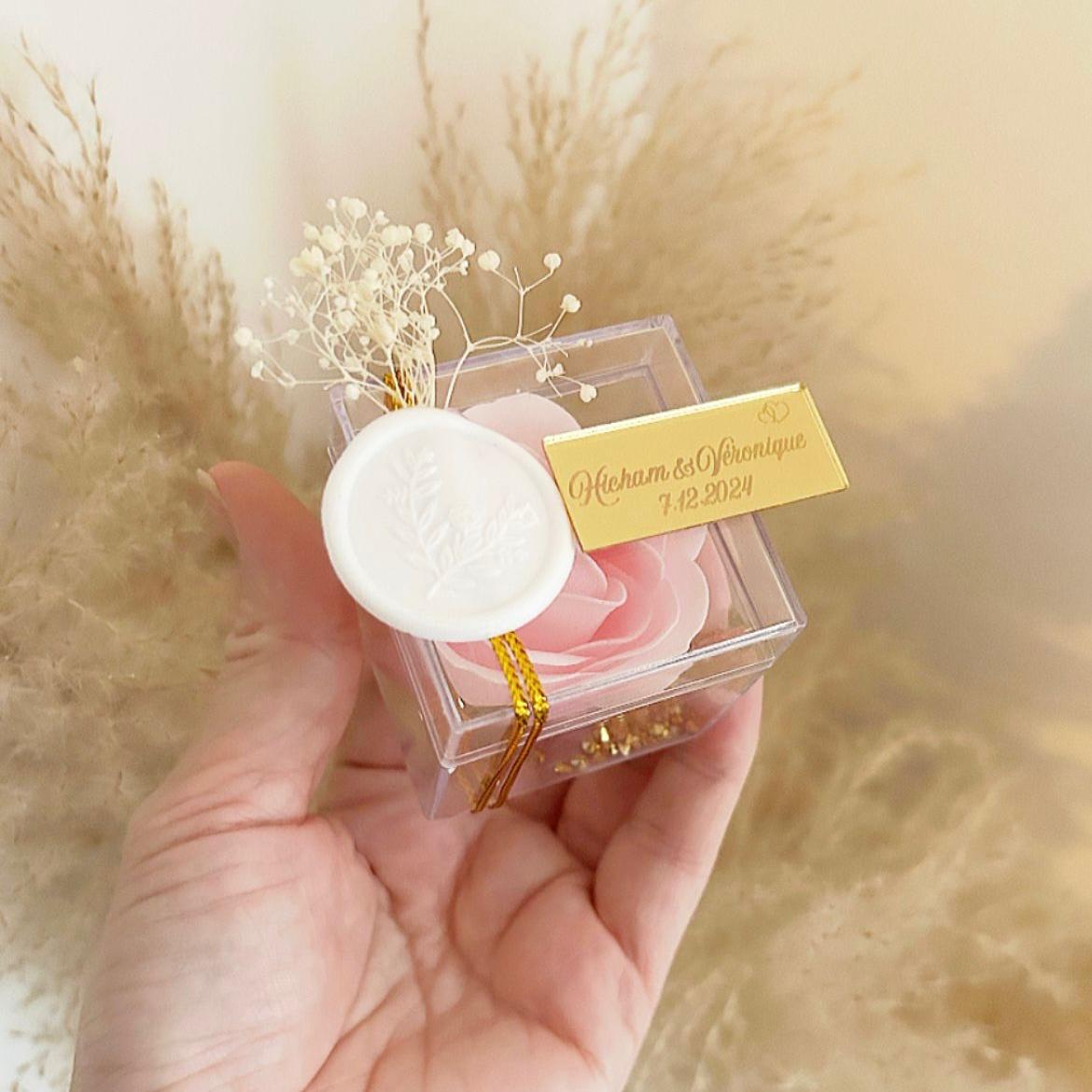 Cadeau invité : rose de savon Soélia rose en boîte plexi avec sceau blanc, fleurs séchées et plaque dorée personnalisée.