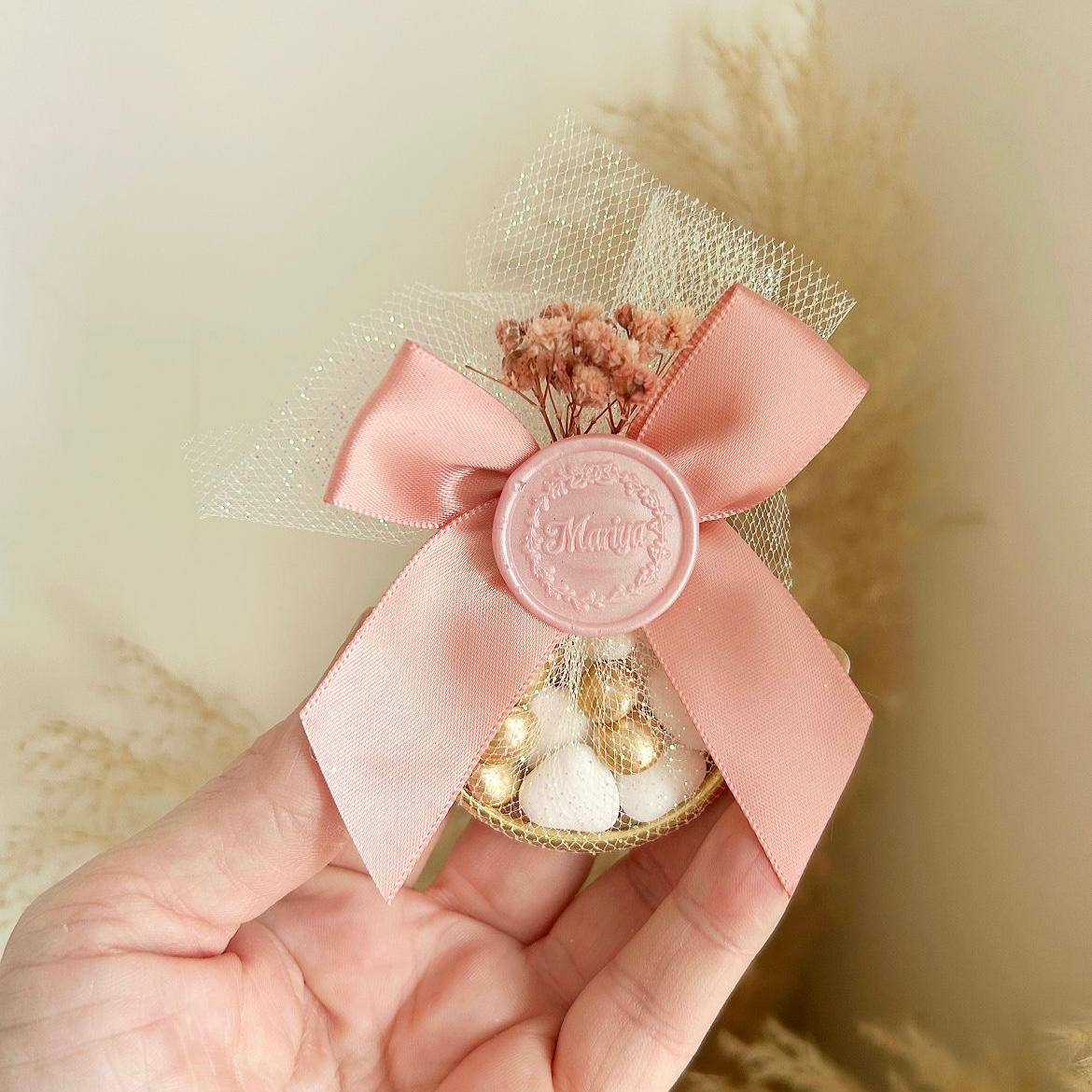 Cadeau invité : sachet de dragées Russia en tulle avec ruban satin rose, sceau décoratif et fleurs séchées.