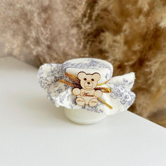 Bougie Jadore Cadeau invité baptême : bougie avec tissu marbré, nœud doré et décoration ourson en bois personnalisé.