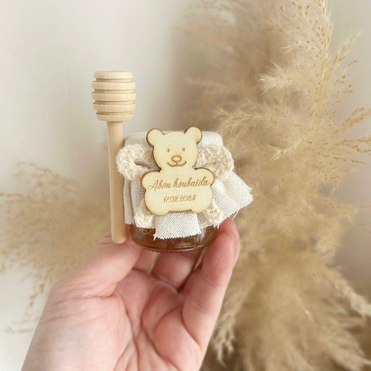 Cadeau invité baptême : petit pot de miel Teddy avec ourson en bois gravé, ruban en tissu et bâtonnet à miel.