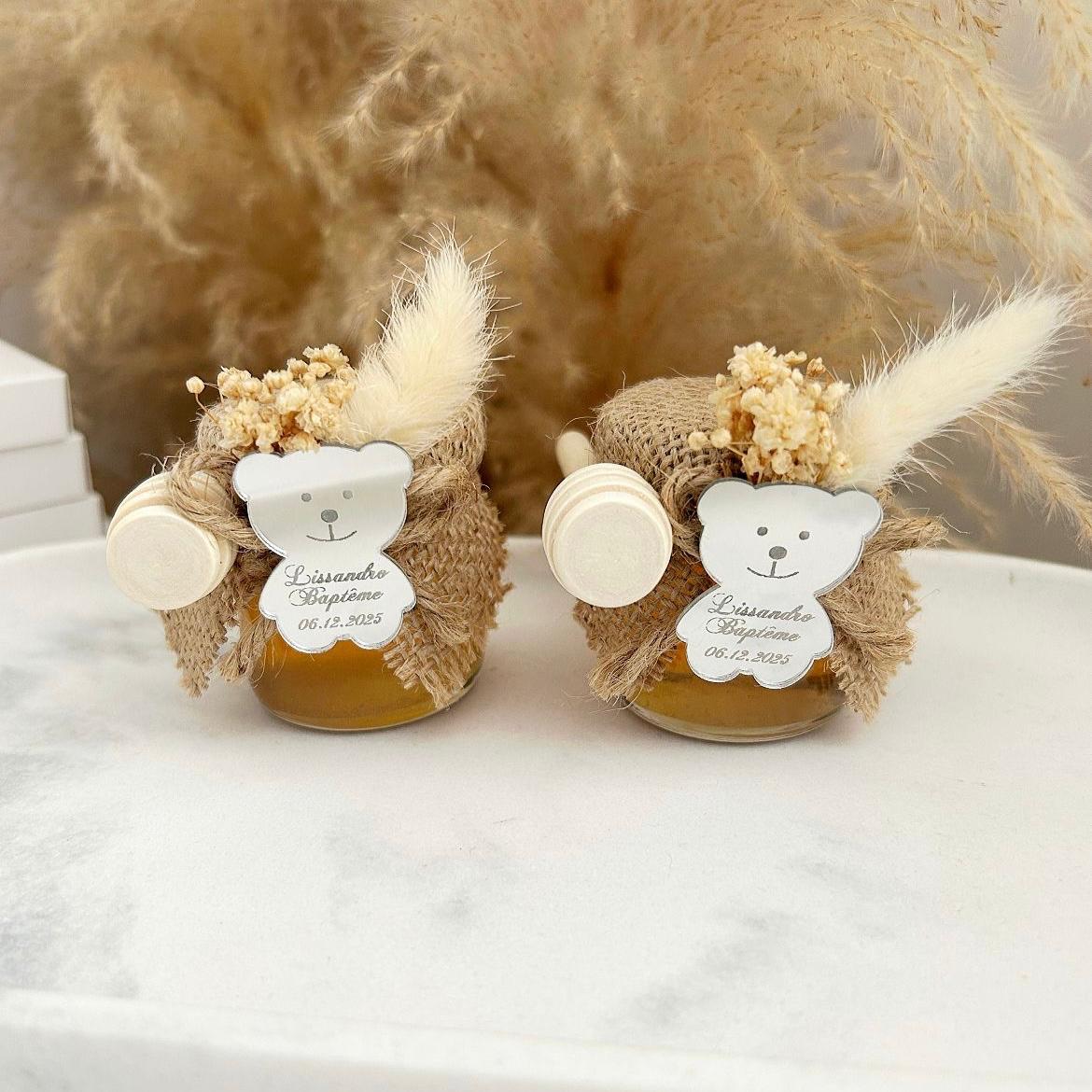 Cadeau invité baptême : petit pot de miel personnalisé avec ourson miroir, jute naturelle, fleurs séchées et cuillère en bois.