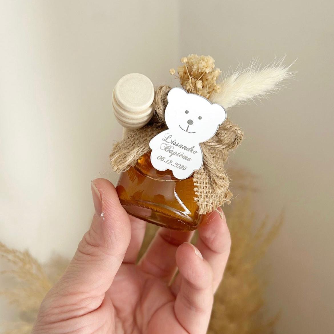 Cadeau invité baptême : petit pot de miel personnalisé avec ourson miroir, jute naturelle, fleurs séchées et cuillère en bois.